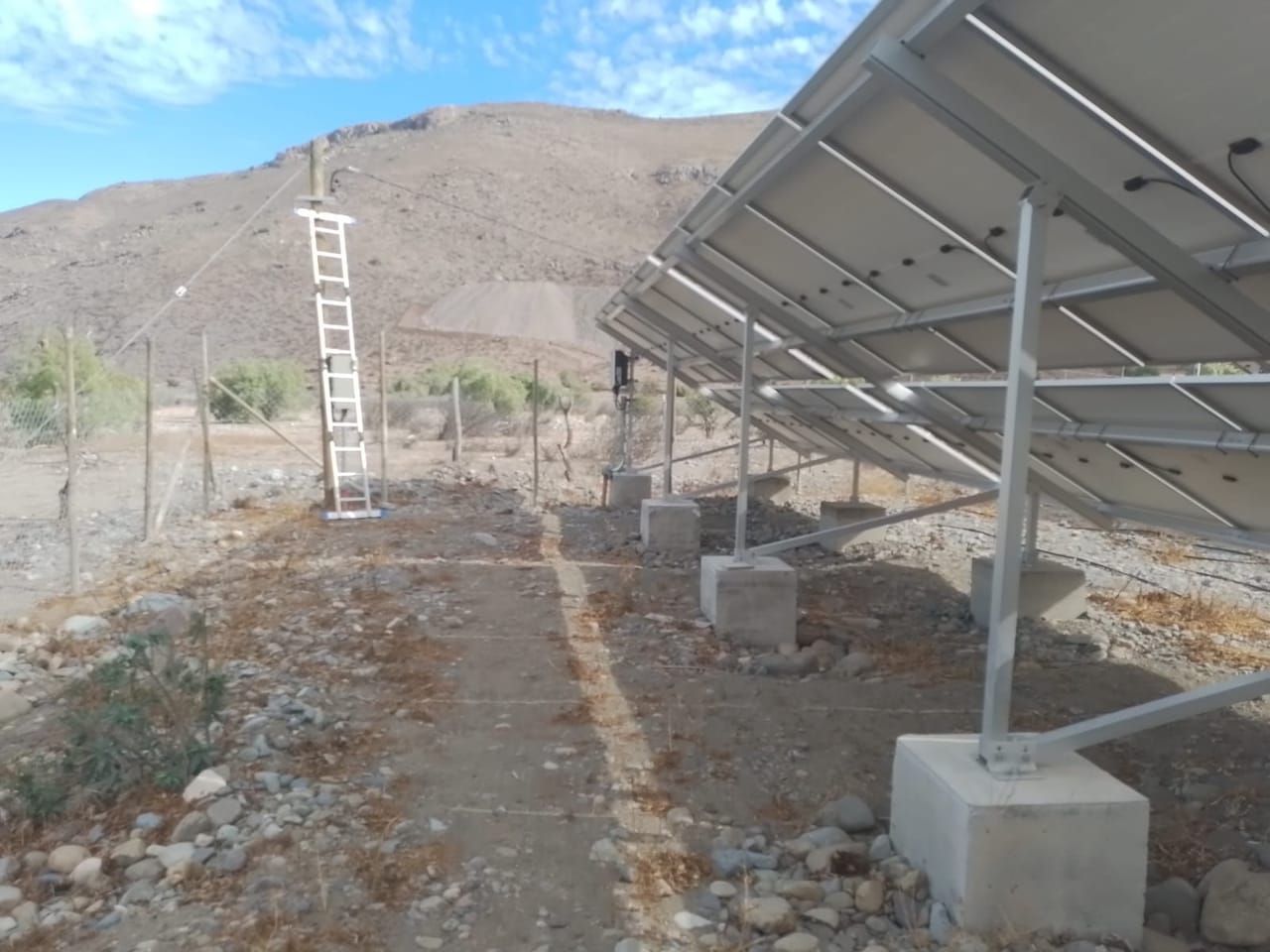 Planta fotovoltaica de paneles solares en terreno agrícola cercado