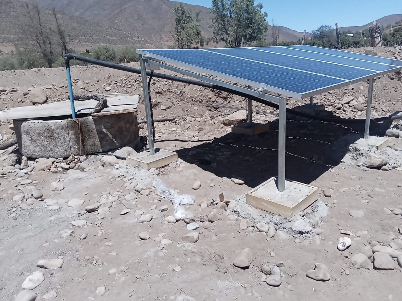 Panel solar sobre pozo de riego, bombeo solar agrícola con cerros al fondo