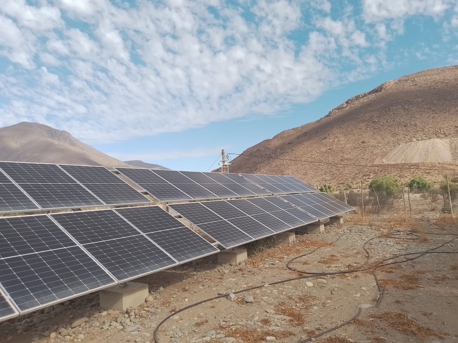 Paneles solares instalados en faena minera, con cerros al fondo